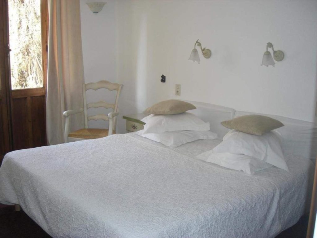 Dormitorio del hotel La Marjolaine con textiles blancos