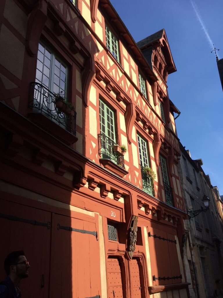 Calle medieval de Le Mans con una casa con entramado de madera de naranja de tres plantas