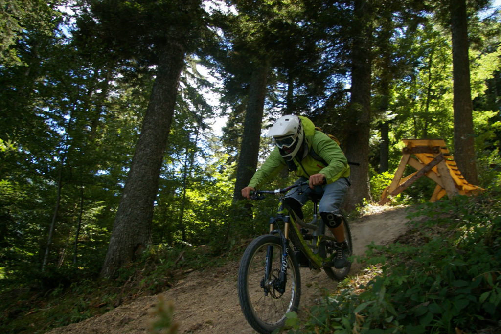 Ciclistas de VTT bajando una fuerte pendiente en una bicicleta con una puerta totalmente protegida en el Col de l'Arzellier