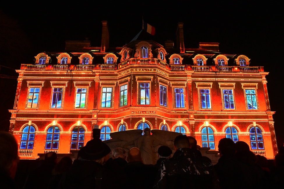 Les Habits de Lumières en Epernay mostrando el salón principal de la ciudad iluminado en rojo y naranja