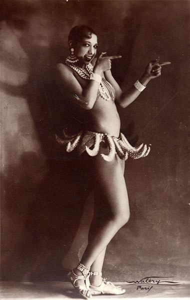 Fotografía en sepia y blanco de Josephine Baker con su famoso traje de cinturón de plátano bailando en el escenario