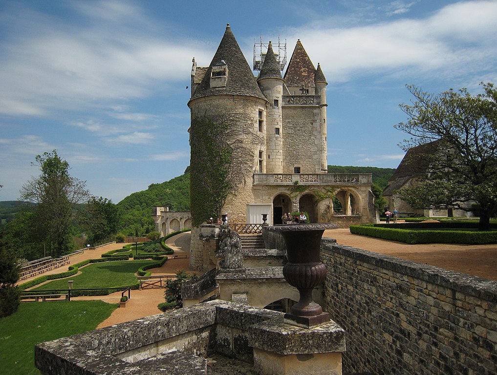 Château des Milandes en Dordogne, la casa de Josephine Baker con una vista lateral que muestra torres altas en el fondo y paredes y una urna de hierro en el frente