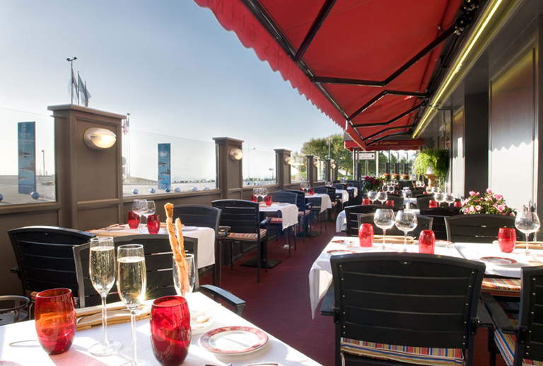 Terraza del restaurante de la matelote Boulogne afuera mirando hacia el mar con mesas puestas