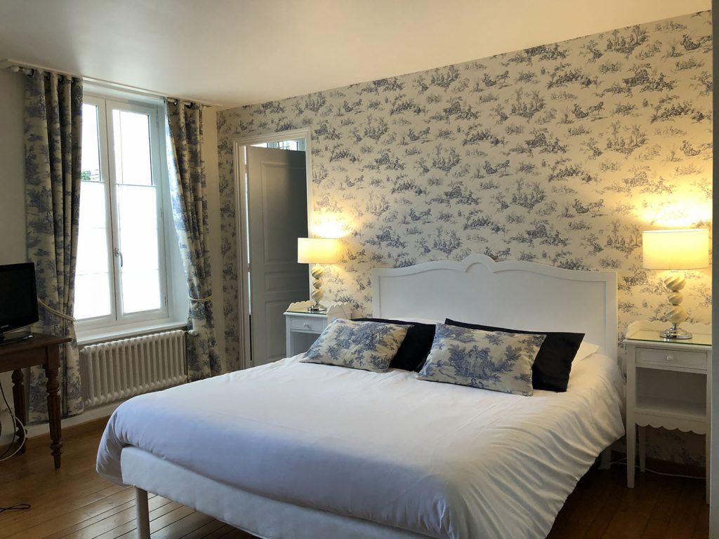 L'enclos de leveche boulogne sur mer Dormitorio Desvres con papel pintado azul y blanco y una cama grande