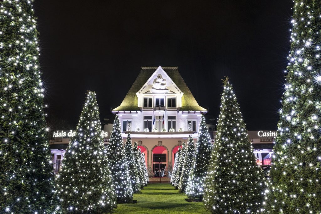 La avenida de árboles de Navidad estaba iluminada y conducía por un camino verde a un edificio estilo chalet suizo anticuado.