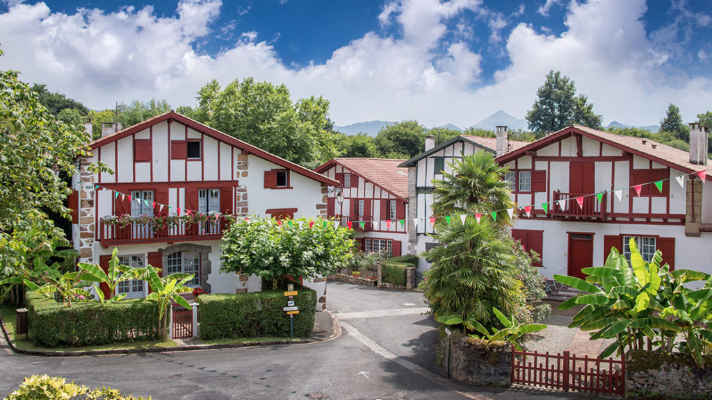 Ainhoa ​​​​en Francia, País Vasco, que muestra casas rojas y blancas de dos pisos en un entorno de pueblo