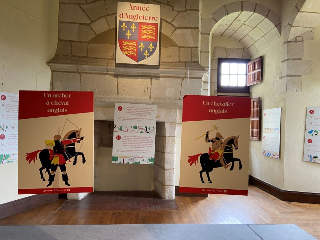 Exposición del castillo de Bauge que muestra al ejército inglés en enormes carteles que cuelgan de la pared de piedra