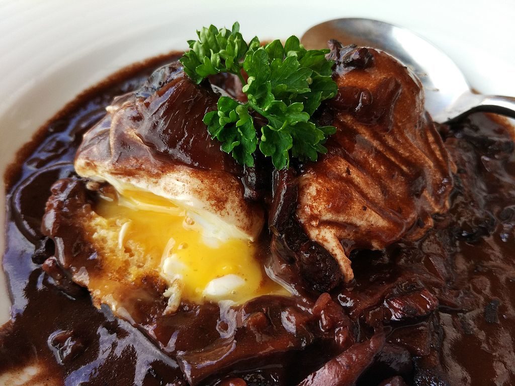 oeufs en meurette plato con carne, perejil, tocino y champiñones en un bol