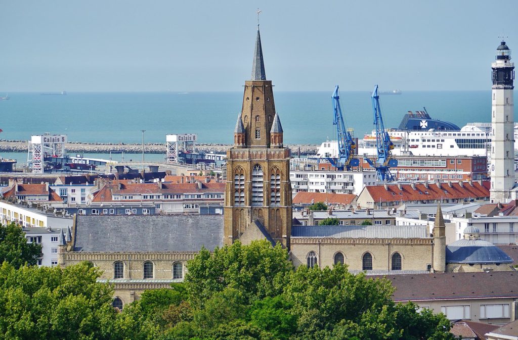 Echa un vistazo a la catedral de Calais con el puerto al fondo.