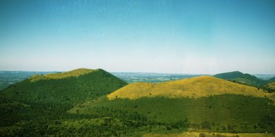 Vista aérea de la región volcánica de Auvernia con amplias colinas verdes y valles profundos