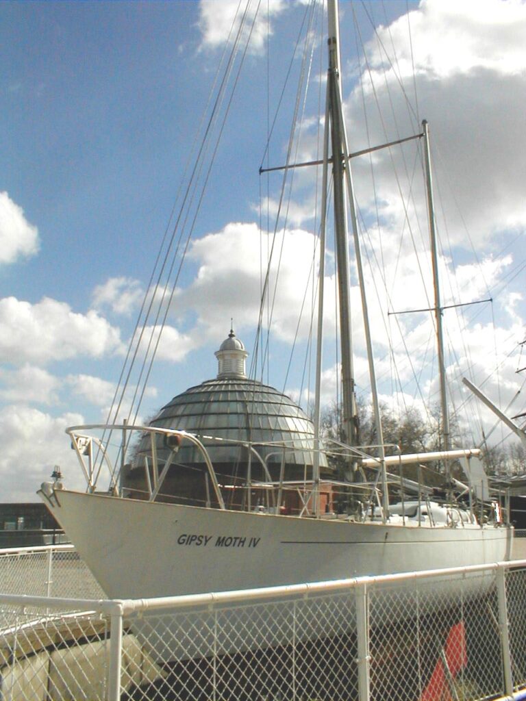 Gipsy Moth montada permanentemente en Greenwich en hormigón con una torre redonda detrás