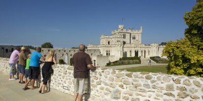 gente mirando por encima de una pared en Chateau Hardelot en la distancia