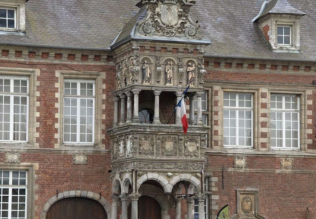 Ayuntamiento de Hesdin al norte de Francia. Una entrada gótica muy detallada en dos pisos de piedra con un frente de ladrillo rojo en la parte trasera