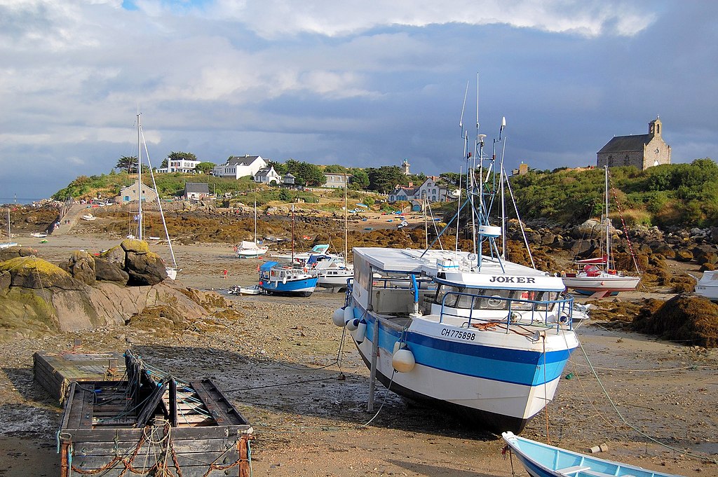 Un barco de pesca en una playa de arena con otros detrás en un puerto en las Islas Chausey, Francia