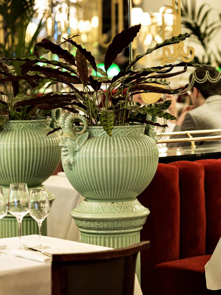 Brasserie Thoumieux en París. Imagen de una maceta en detalle desde el interior con personas detrás en las mesas y vasos a la izquierda