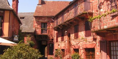 el pueblo de Collonges-la-Rouge. Una calle con casas de piedra roja a un lado con techos empinados