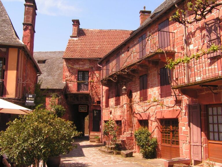 el pueblo de Collonges-la-Rouge. Una calle con casas de piedra roja a un lado con techos empinados