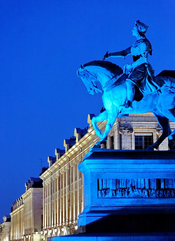 Noche en Orleans con una estatua de Joabán de Arco visible frente a un edificio neoclásico