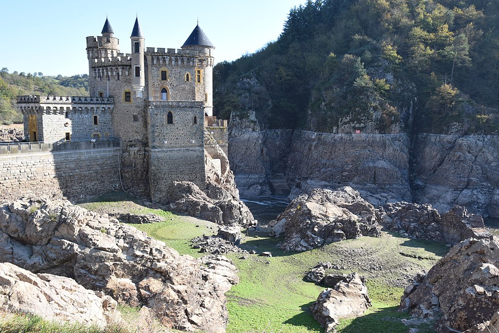 Château de La Roche Valle del Loira que muestra un castillo medieval sobre rocas con más rocas en el suelo por delante, enormes muros altos y colinas más allá