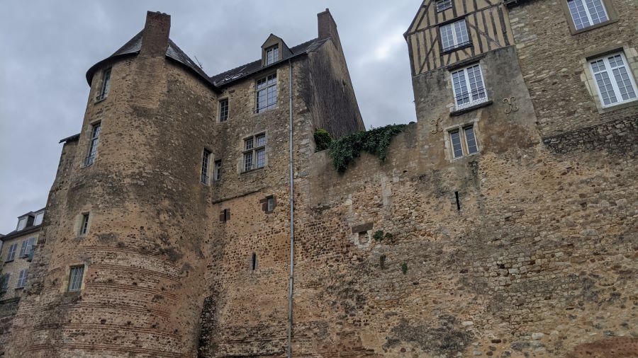 Una muralla romana en Le Mans con tejas rojas y piedra y casas medievales construidas arriba