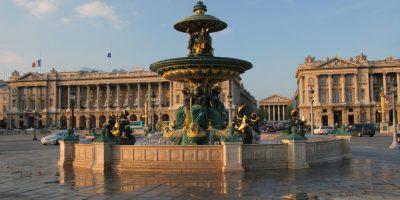 Place de la Concorde en París con una fuente ornamentada en primer plano y edificios neoclásicos del siglo XIX detrás