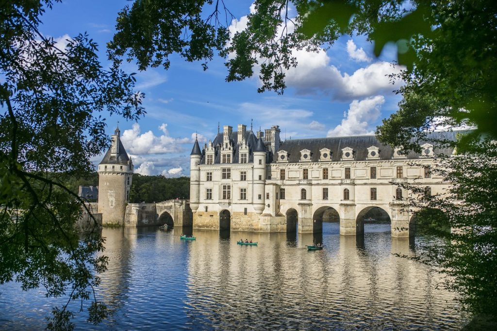 Chateau de Chenonceau construido en el lago con sus paredes blancas y torres visibles en el agua