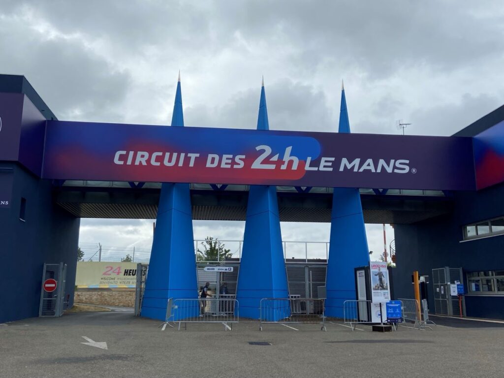 Entrada al circuito de Le Mans que muestra columnas azules con el letrero punteado Circuit des 24 h Le Mans en colores