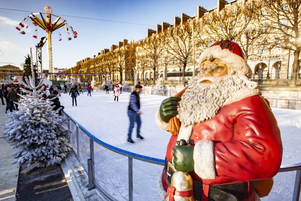 Paris Jardin des Tuileries en el mercado navideño con gente patinando, un árbol de Navidad nevando y una figura de Papá Noel volada