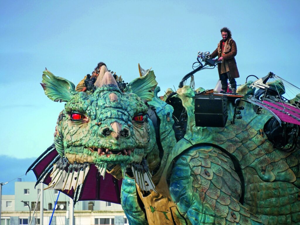 La enorme bestia mecánica de Calais Dragon mirando a la cámara con mucho encima que funciona sobre tres ruedas que parece Julio Verne
